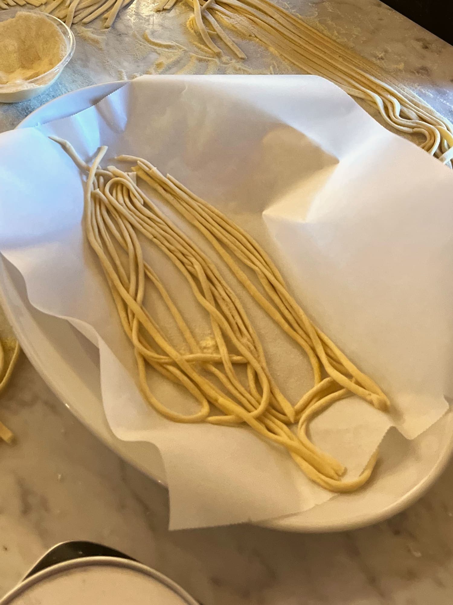 Pasta fresca sul piano di marmo, tagliata e pronta per la pentola.